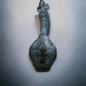 distressed blue cast iron decorative bottle or vase featuring a fleur-de-lis...